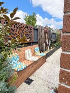 a wooden bench with chairs on a patio at Cozy room with an Ensuite in Clyde North +3 photos