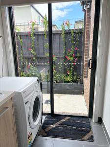 a washing machine in a kitchen with a window at Cozy room with an Ensuite in Clyde North