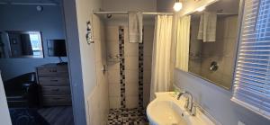 a bathroom with a sink and a shower and a tub at Le Pirate Motel et Camping in Cap-Chat +31 photos
