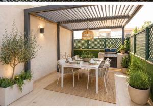 a patio with a table and chairs on a balcony at AMAZING ROOFTOP, 70 M TERRACE,Pool,BEACH,PARKING in Málaga