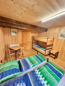 a room with two bunk beds and a table at Wippertaler Hütte in Kleinfurra