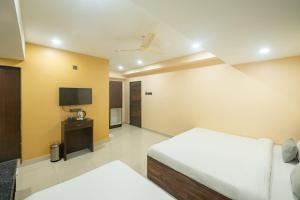 a hotel room with a bed and a tv at Hotel Pravasa stay ,Shirdi in Shirdi