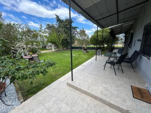 a patio with a table and chairs and a yard at christos cottage! comfortable and quiet! in Keramoti