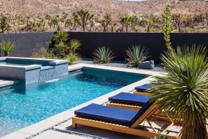 a pool with chaise lounge chairs and a swimming pool at Black C House Modern w pool spa in Yucca Valley