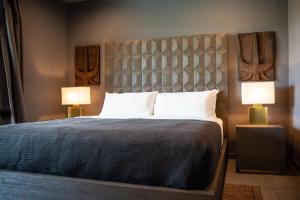 a bedroom with a large bed with two lamps at Black C House Modern w pool spa in Yucca Valley +24 photos