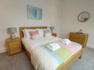a bedroom with a large bed with towels on it at Glynllifon 7 in Llanallgo