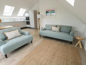a living room with two chairs and a couch at Glynllifon 7 in Llanallgo