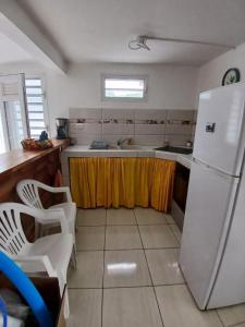 a kitchen with a white refrigerator and a sink at Résidence EmiRose in Rivière-Pilote +6 photos
