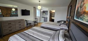 a hotel room with two beds and a television at Le Pirate Motel et Camping in Cap-Chat