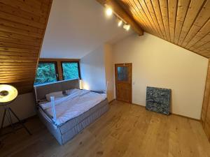 an attic bedroom with a bed and a wooden ceiling at Nürburgring Eifelhaus in Baar
