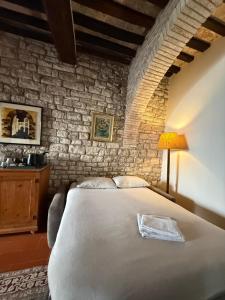 a bedroom with a bed and a stone wall at Residenza Via Felicchi 10 in Gubbio