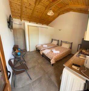 a room with two beds and a table in it at Mani Sea View Rooms in Gythio