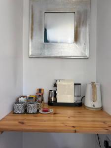 a wooden counter top with a microwave and a mirror at Shangri-La in Chesham