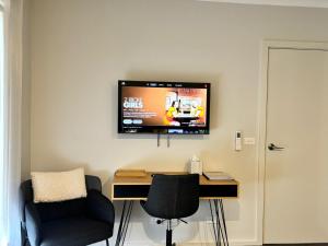 a room with a desk and a tv on the wall at Cozy room with an Ensuite in Clyde North