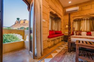 a room with two beds and a window with a view at Golden Celestial haveli jaisalmer in Jaisalmer