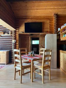 a dining room with a table and chairs and a television at See Paradies am Keltenberg in Wiesen