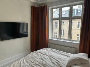 a bedroom with a bed and a large window at Bright apartment in central Copenhagen in Copenhagen