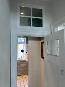 a kitchen with a window and a door to a room at Bright apartment in central Copenhagen in Copenhagen