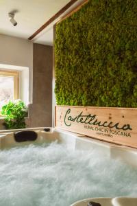 a bath tub in a bathroom with a green wall at Il Castelluccio Country Resort Restaurant & SPA in Barberino di Mugello