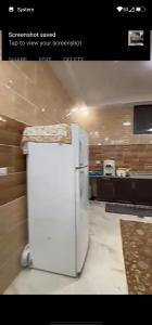 a white refrigerator in a room with a kitchen at فيلا سالم الاشقر in Amman