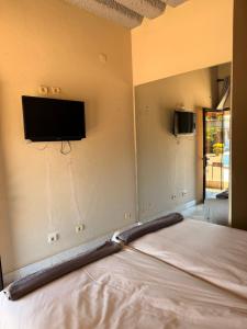 a room with a bed and a tv on the wall at Executive Manica Hotel in Chimoio