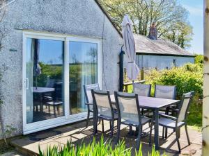 a table and chairs on the patio of a cottage at Angerton Cottage in Carlisle