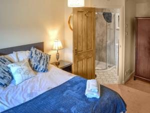 a bedroom with a bed and a walk in shower at Angerton Cottage in Carlisle