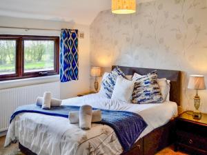 a bedroom with a large bed and two windows at Angerton Cottage in Carlisle +11 photos