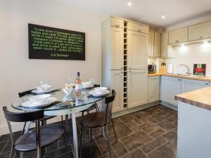 a kitchen with a table and chairs in a kitchen at Smugglers Den in Beadnell