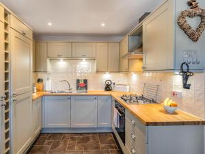 a kitchen with white cabinets and a counter top at Smugglers Den in Beadnell