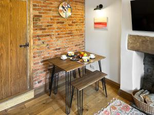 a small table in a room with a brick wall at Bailey Cottage in Staindrop