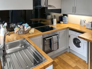 a kitchen with a sink and a washing machine at Bailey Cottage in Staindrop +5 photos