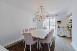 a dining room with a table and chairs and a chandelier at Lovely Villa - By Y Concept in Setúbal