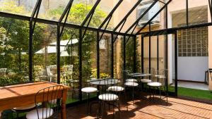 a patio with tables and chairs in a glass house at Al Battistero Luxury Suite in Ravenna
