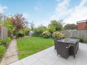 a garden with a table and chairs on a patio at Whit's End House in Whitstable