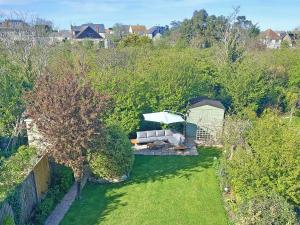 an overhead view of a garden with a couch and an umbrella at Whit's End House in Whitstable