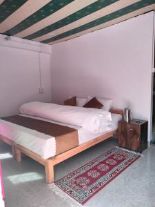 a bedroom with a bed with a wooden frame at Rautelahomestay in Harsil