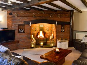 a living room with a brick fireplace with candles at Lambourne House - Ukc2831 in Skegness