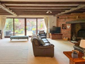 a living room with a leather couch and a fireplace at Lambourne House - Ukc2831 in Skegness +43 photos