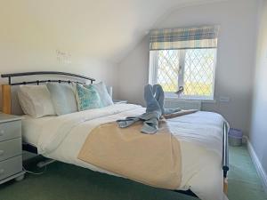 a bedroom with a bed with a pair of shoes on it at Hayloft-E2699 in Winthorpe