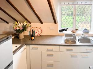 a kitchen with white cabinets and a sink and two windows at Hayloft-E2699 in Winthorpe