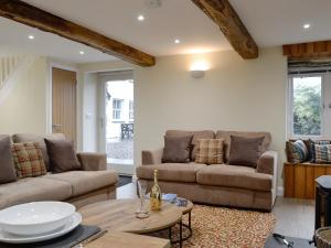 a living room with two couches and a table at Tarn Rigg Cottage - Uk1368 in Keswick