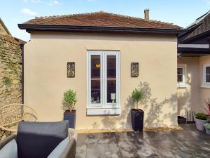 a house with a patio with a couch and a window at The Colleys in Lechlade