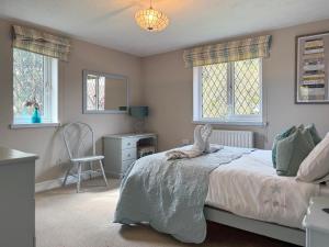 a bedroom with a bed and a chair and windows at Archways-E1223 in Addlethorpe