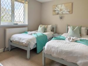 two twin beds in a room with two windows at Archways-E1223 in Addlethorpe