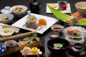 a table topped with plates of food and bowls of food at Sanyo-so in Izunokuni