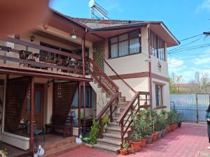 a house with stairs and plants in front of it at Casa Ecaterina 2Mai in 2 Mai