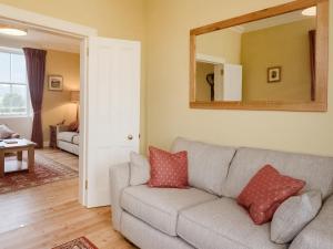a living room with a couch and a mirror at Broomrigg Farmhouse in Pencaitland +16 photos