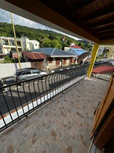 a balcony with a fence and a car on a street at La Kaz a Madras in Deshaies