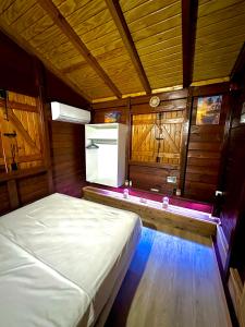 a bedroom with a bed in a room with wooden walls at La Kaz a Madras in Deshaies